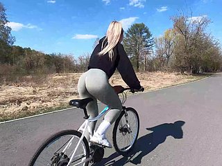 Blonde wielrenster toont perzikvriend aan haar right hand en neukt in the air een openbaar park